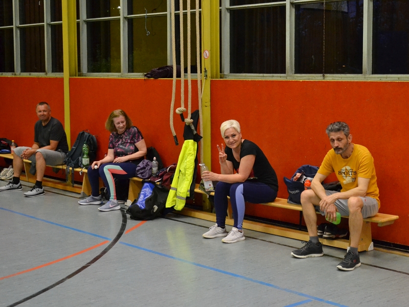 Tischttennisspieler auf der Bank schauen beim Spiel zu